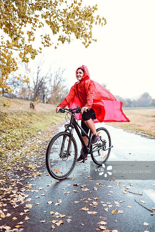 骑自行车的人在公园雨中享受骑行乐趣图片素材