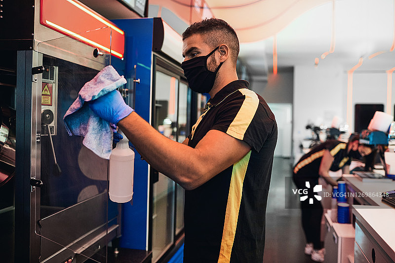 疫情后重新开放的电影院，员工清洁爆米花机图片素材