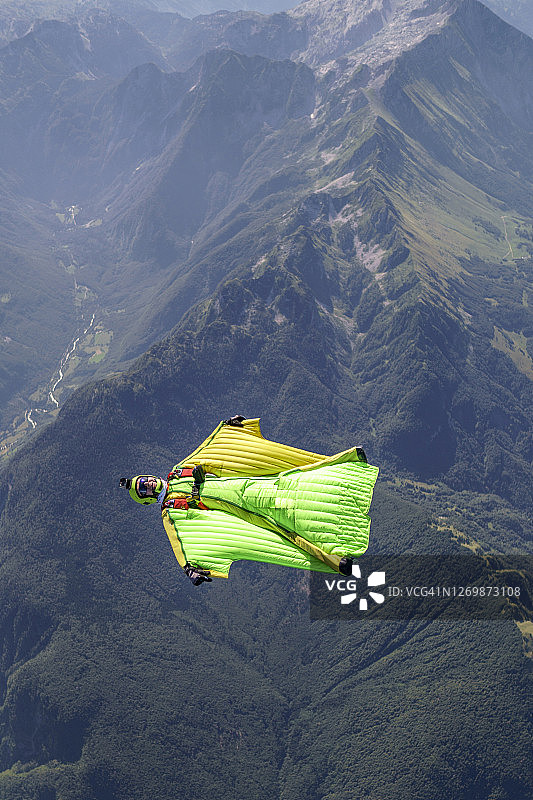 翼装飞行员在山地景观上空编队飞行图片素材