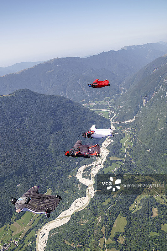 翼装飞行员在山地景观上空编队飞行图片素材