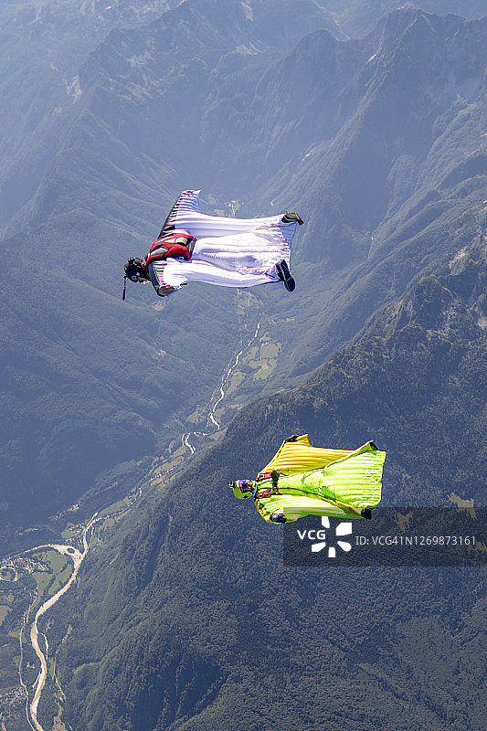 翼装飞行员在山地景观上空编队飞行图片素材