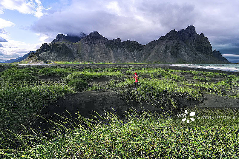 女子眺望冰岛Vestrahorn蝙蝠侠山，冰岛夏季风光图片素材