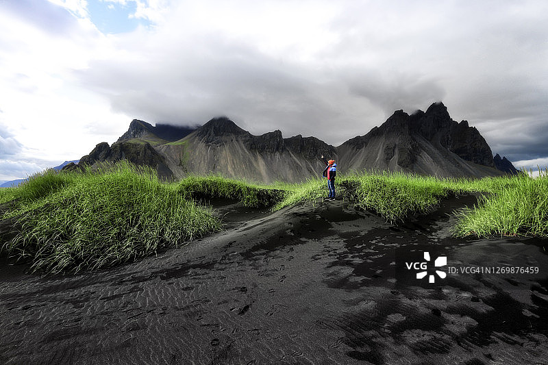 女子眺望冰岛Vestrahorn蝙蝠侠山，冰岛夏季风光图片素材