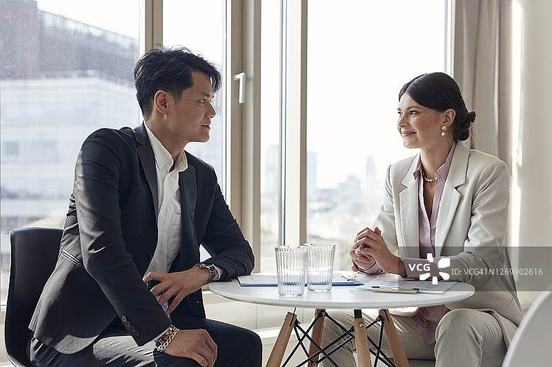 会议室：有魅力的女商人与亚洲合伙人达成交易，迎来新投资图片素材