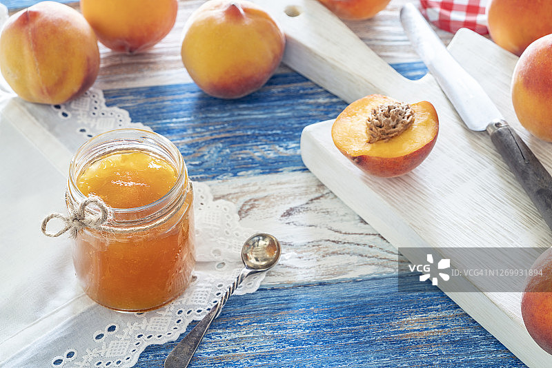 装在玻璃罐中的自制桃子酱与砧板上的桃子图片素材