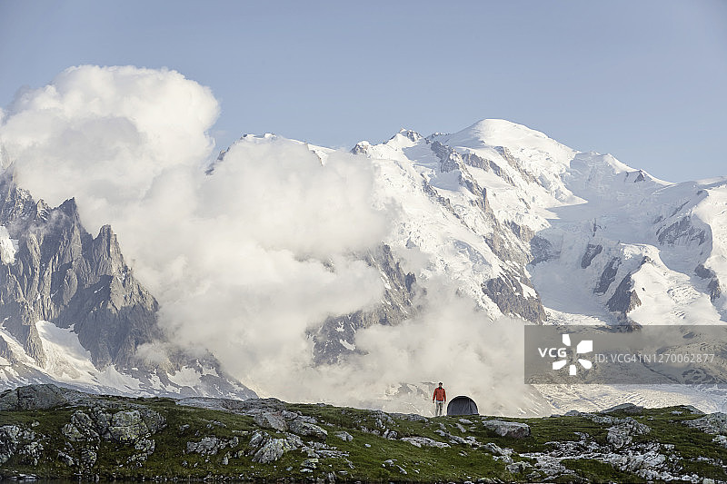 徒步者站在有帐篷的山前图片素材