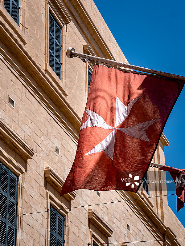 带有街道和蓝天背景的马耳他十字旗图片素材