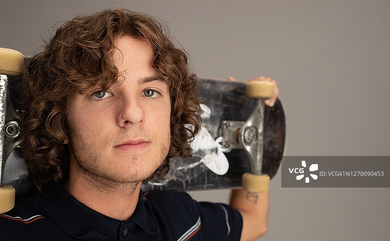 年轻男性滑板运动员和他的滑板合影图片素材