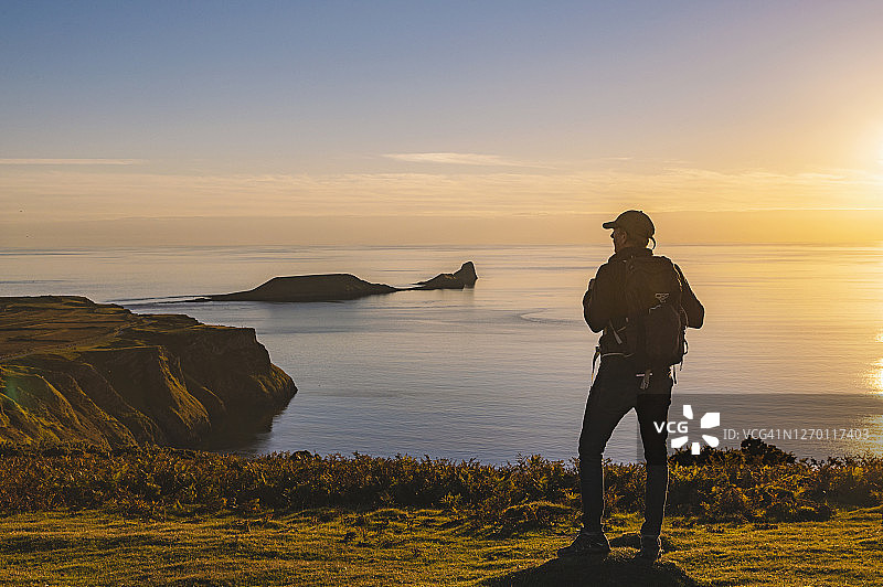 男子欣赏罗斯里湾的日落美景图片素材