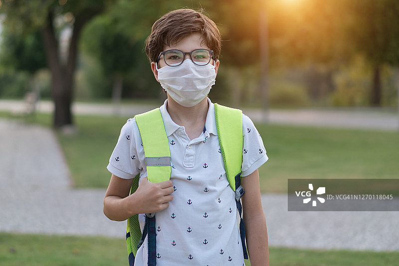 戴防护口罩和背包的男学生肖像图片素材