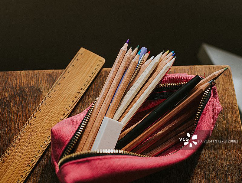 装满铅笔和钢笔的粉色铅笔盒图片素材
