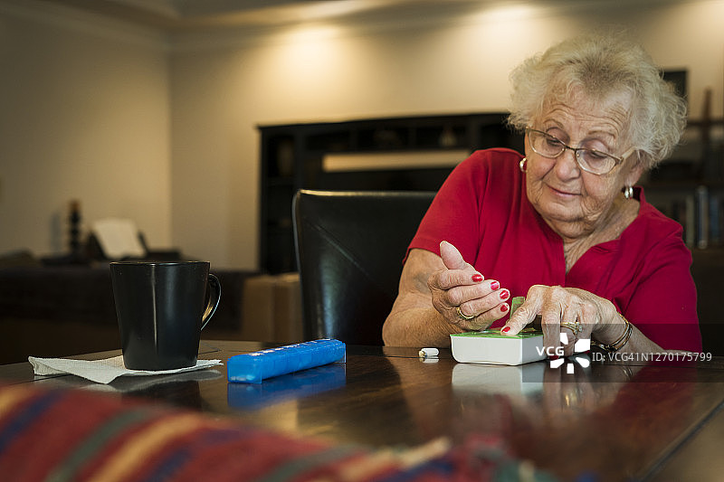 女人将药物整理到药盒中图片素材