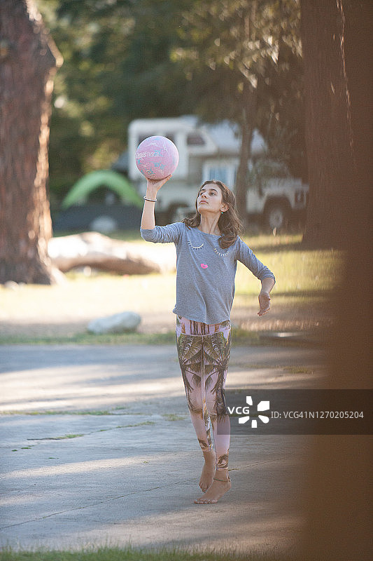 一位年轻漂亮的女孩在户外投篮图片素材