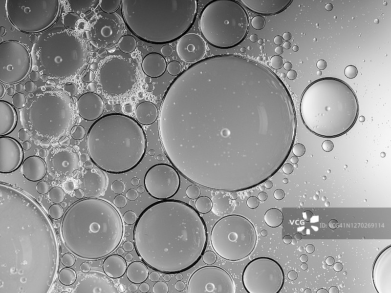 银色液体背景上的气泡和水滴形成的抽象形状和纹理图片素材