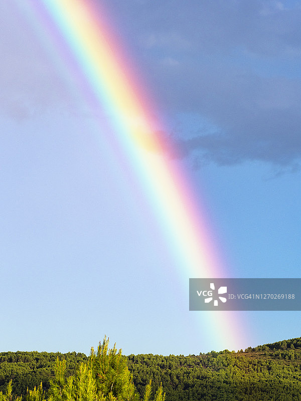 暴风雨过后蓝天上的彩虹与阳光图片素材