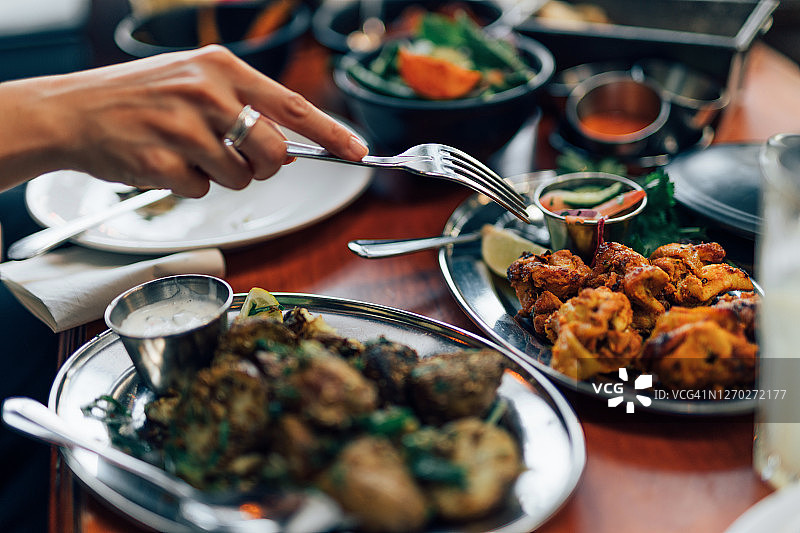 特写：女人用叉子吃印度 Tikka 鸡肉图片素材