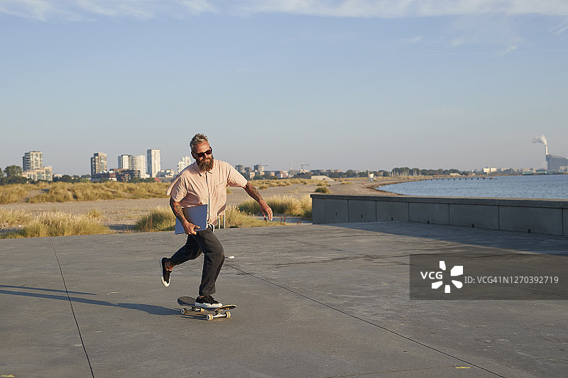 在人行道上玩滑板的男人图片素材