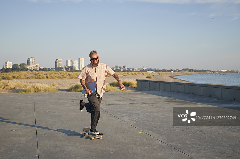 在人行道上玩滑板的时尚人士图片素材