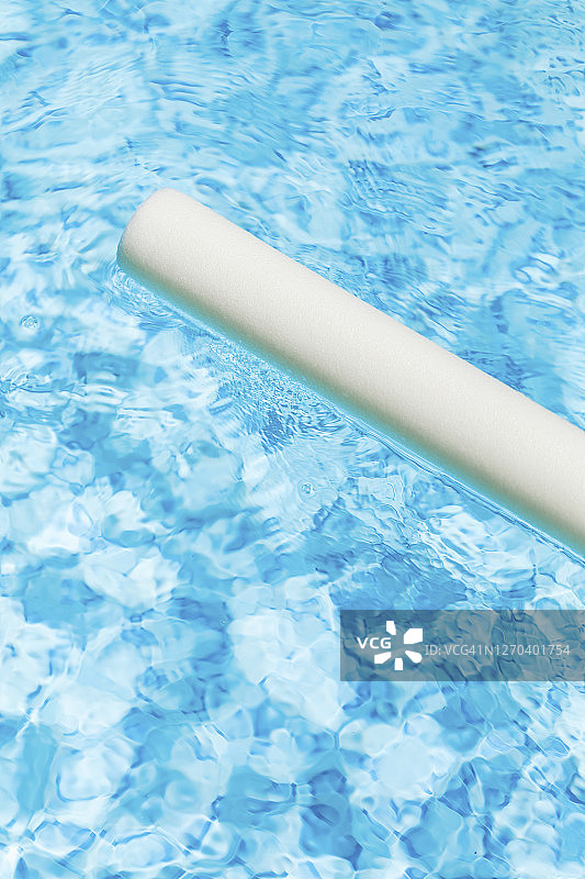 游泳池和漂浮在水面上的泡沫棒特写图片素材