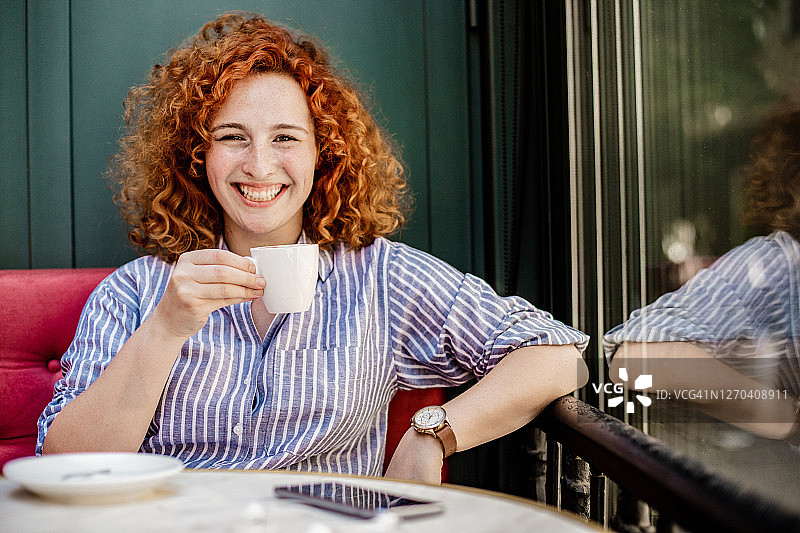 年轻女人坐在咖啡馆里享受咖啡图片素材