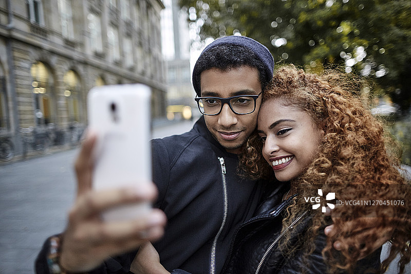 在城市自拍的微笑年轻情侣图片素材