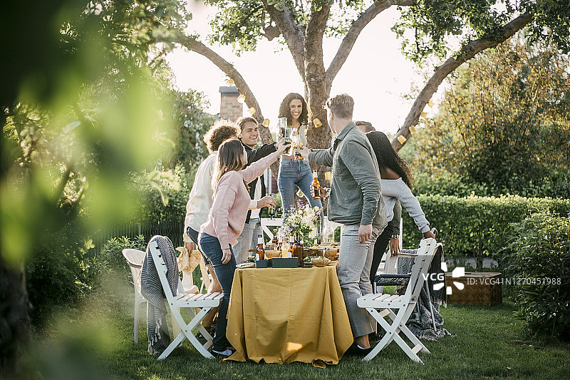 在花园派对上用啤酒碰杯的男女朋友图片素材