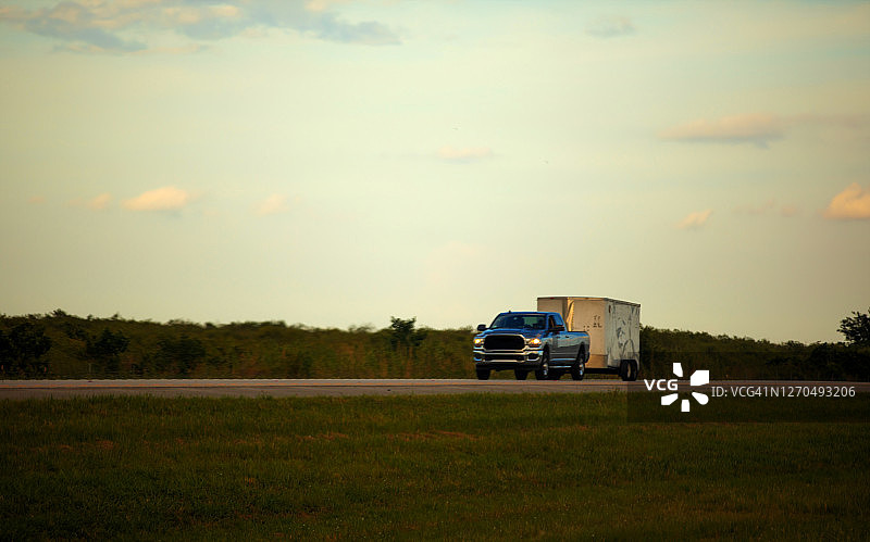 在佛罗里达州行驶的拖着小型拖车的皮卡车图片素材