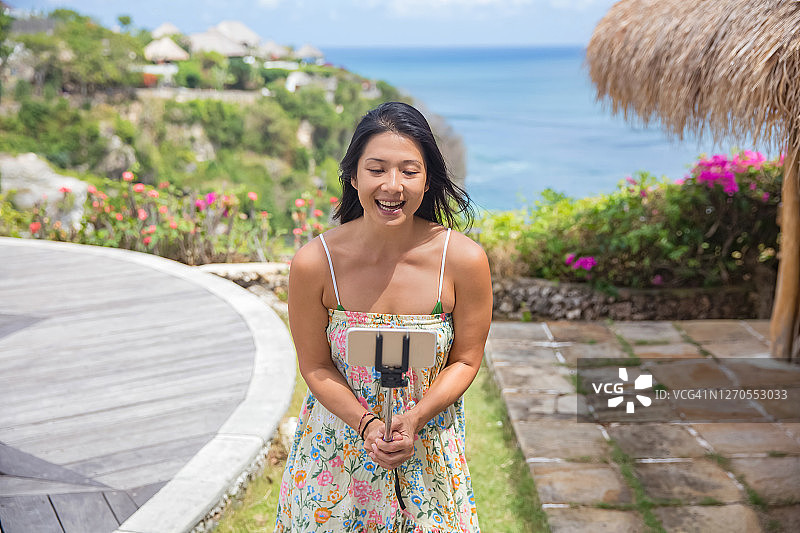 中国游客在美丽的海滨度假胜地用智能手机自拍图片素材