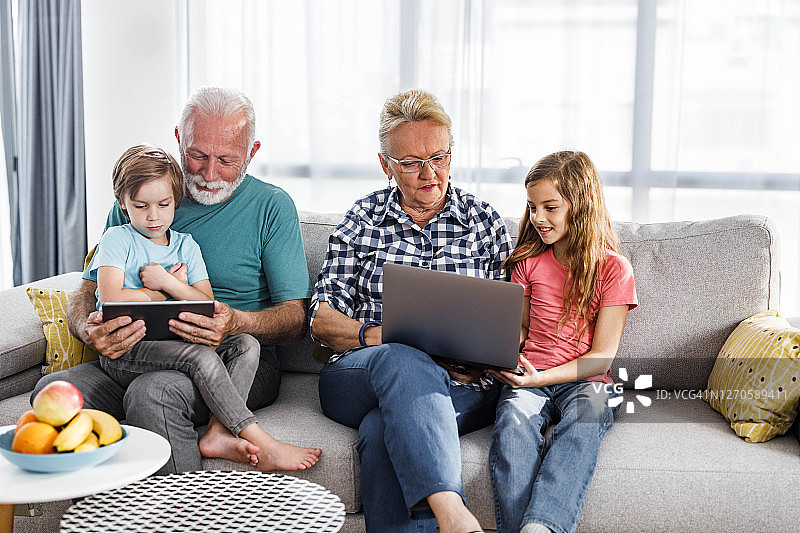 老年人与小孙子在家中使用无线科技产品图片素材