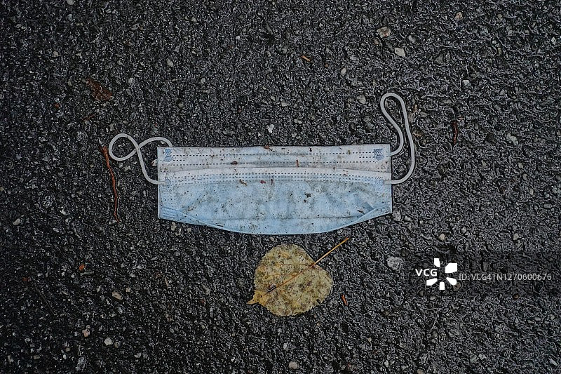 2020年新冠疫情期间，湿地板上的一次性湿口罩图片素材