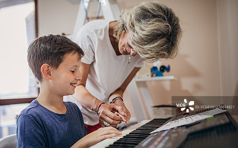 男孩和女老师一起上钢琴课图片素材