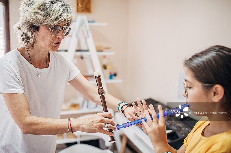 音乐课上，女孩和女老师一起吹长笛图片素材