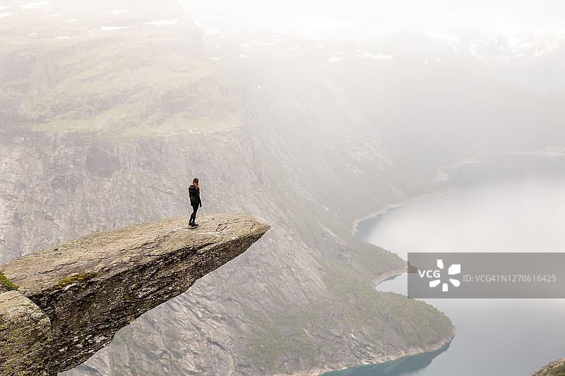 一名女子徒步旅行后在挪威的巨人之舌山顶欣赏风景图片素材