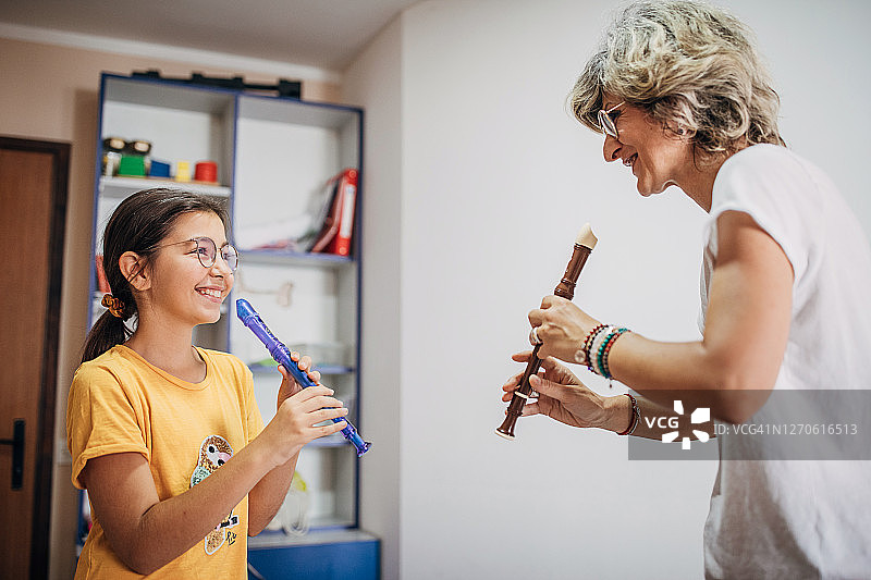 女孩和女老师在音乐课上一起吹长笛图片素材