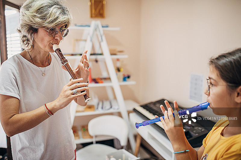 在儿童发展中心，学前班学生和音乐老师一起学习演奏短笛图片素材