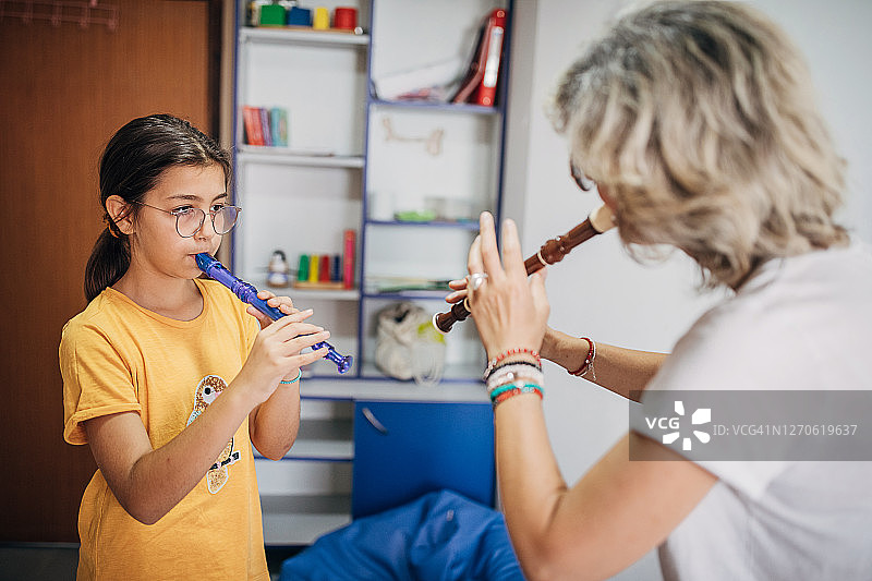 学前班学生在音乐老师的指导下学习演奏短笛图片素材