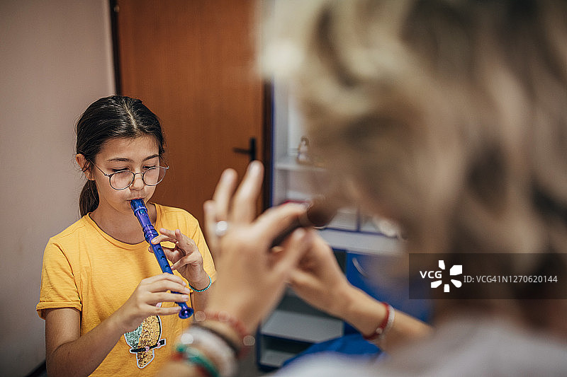 幼儿园女孩在儿童发展中心学习如何演奏短笛图片素材