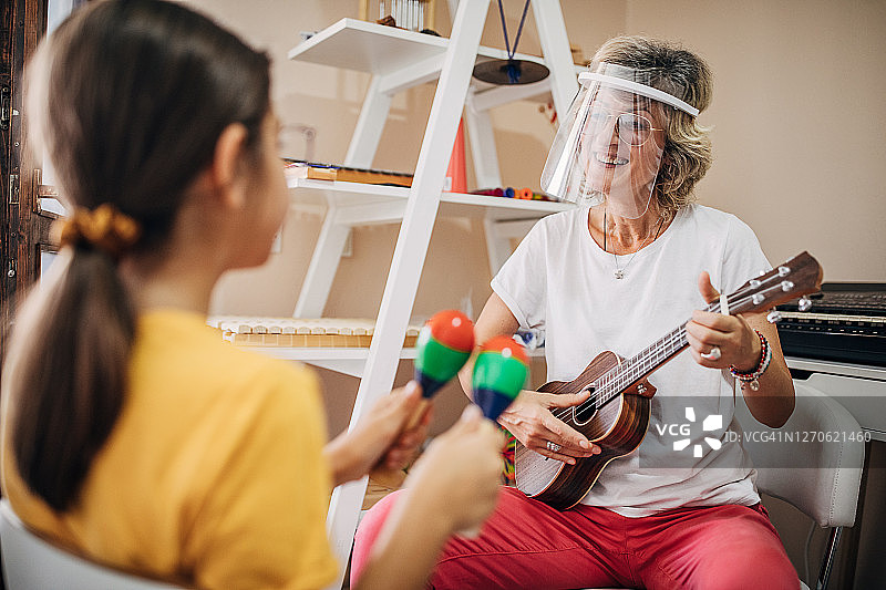 在儿童发展中心与音乐老师一起玩耍的学龄前学生图片素材