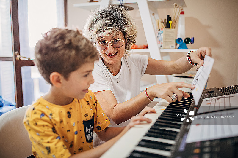学龄前儿童和音乐老师学习如何弹奏合成器图片素材