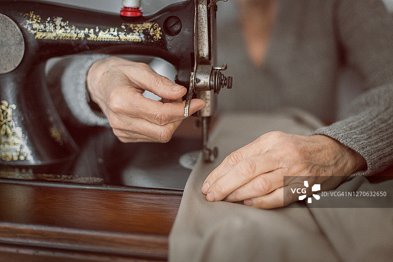 操作老式缝纫机的年长女性图片素材