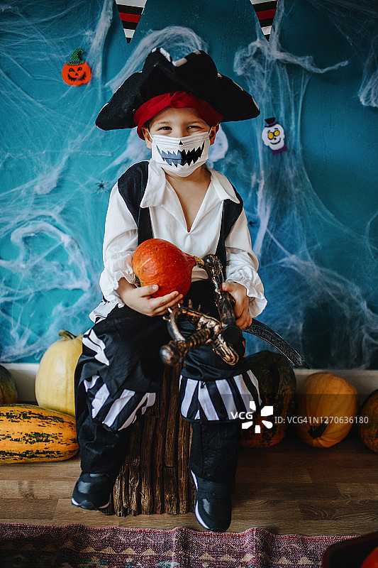 疫情期间，小男孩戴着万圣节服装和防护口罩图片素材