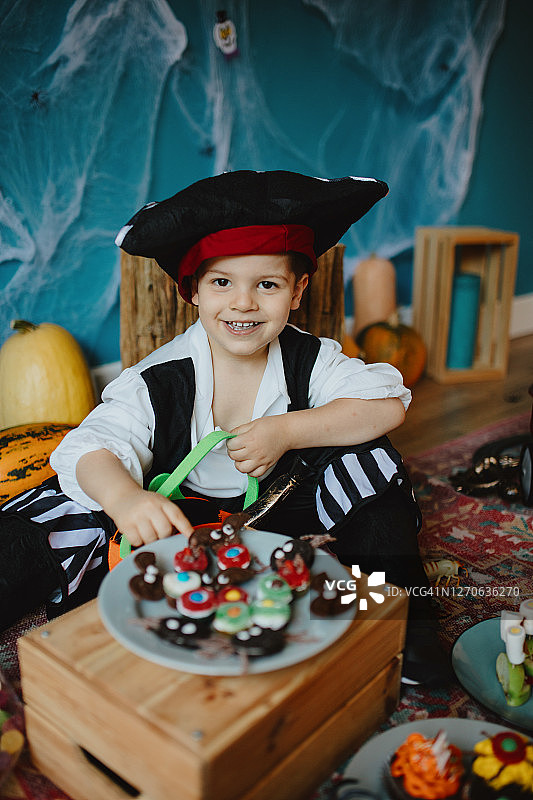 可爱的小男孩在家把糖果放进小篮子里图片素材