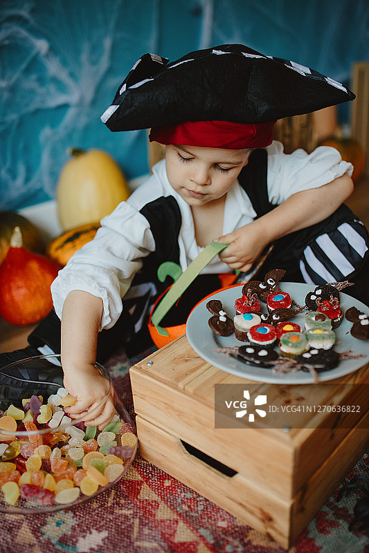 可爱的小男孩在家把糖果放进小篮子里图片素材