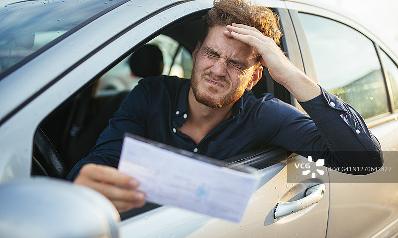 沮丧的年轻人收到停车罚单图片素材