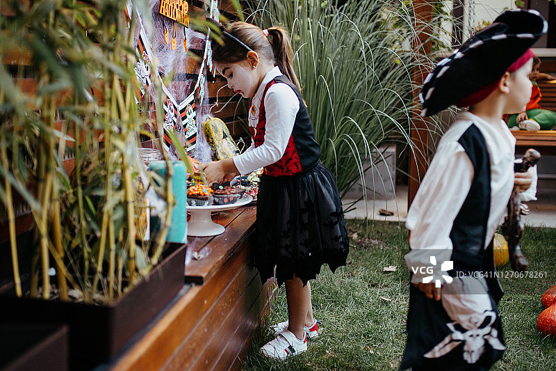 孩子们在后院的万圣节派对上吃糖果图片素材