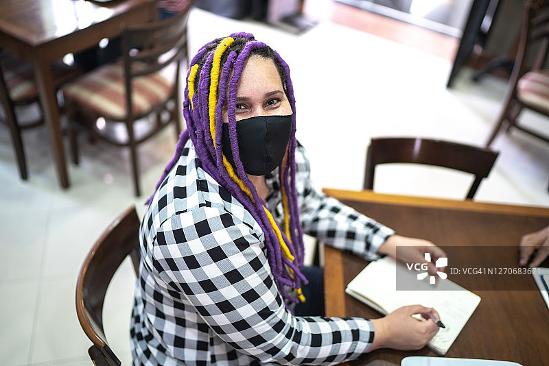 在咖啡店戴着口罩的女性肖像图片素材