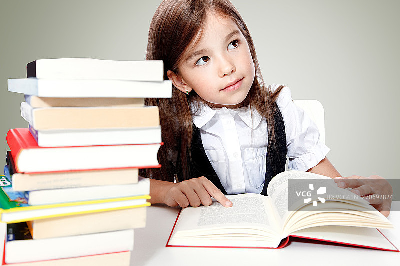坐在桌旁看书的年轻可爱女孩图片素材