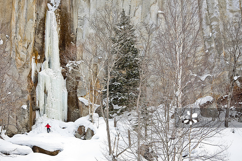 男人站在日本北海道大雪山国立公园层云峡冰冻瀑布下图片素材