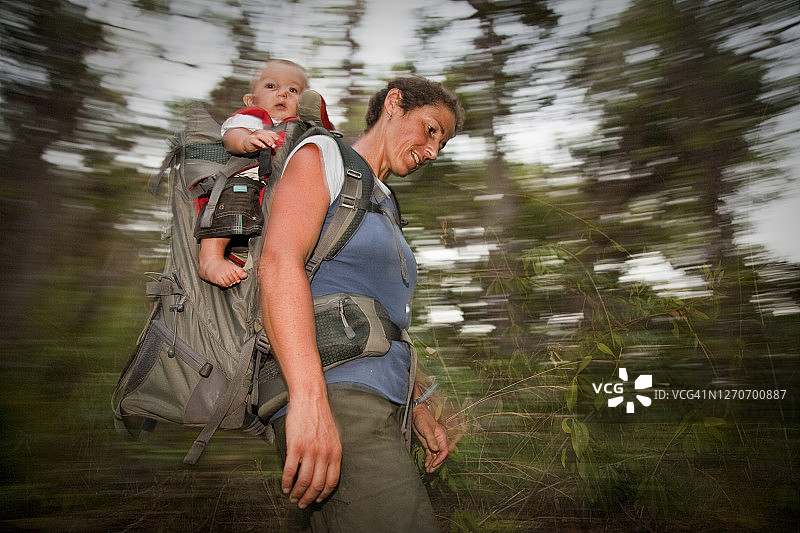 在澳大利亚昆士兰州欣钦布鲁克岛，一位妇女用背包背着她的孩子图片素材
