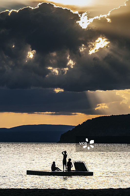 孩子们在新西兰怀卡托金洛赫陶波湖的浮动平台上玩耍图片素材